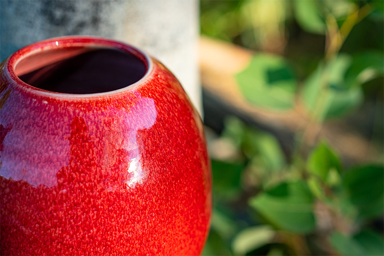 closeup of copper red vase round vase hand thrown by potter Converse Fields photographed outside in Steamboat Springs Colorado