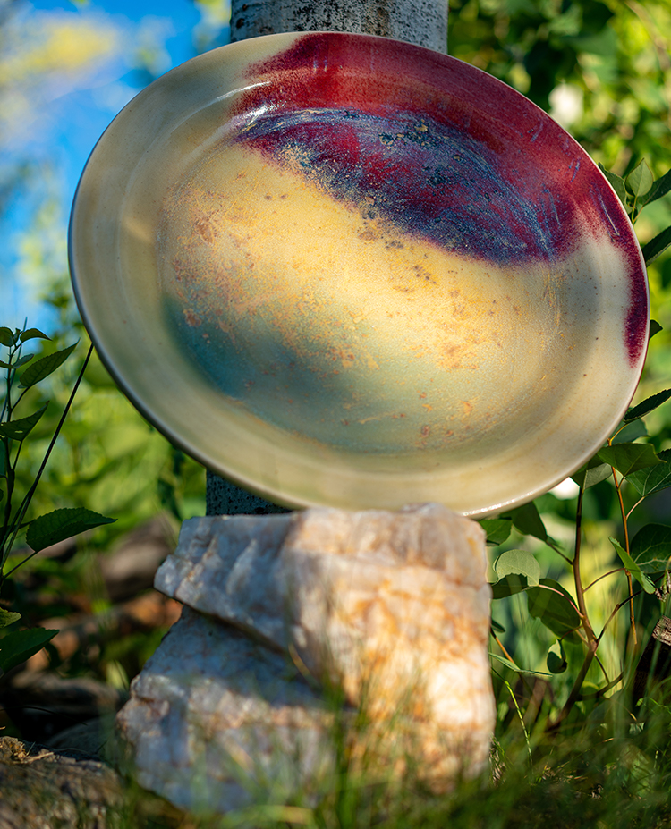 large mustard and red splash hand thrown stoneware platter by Converse Fields photographed outside in Steamboat Springs Colorado