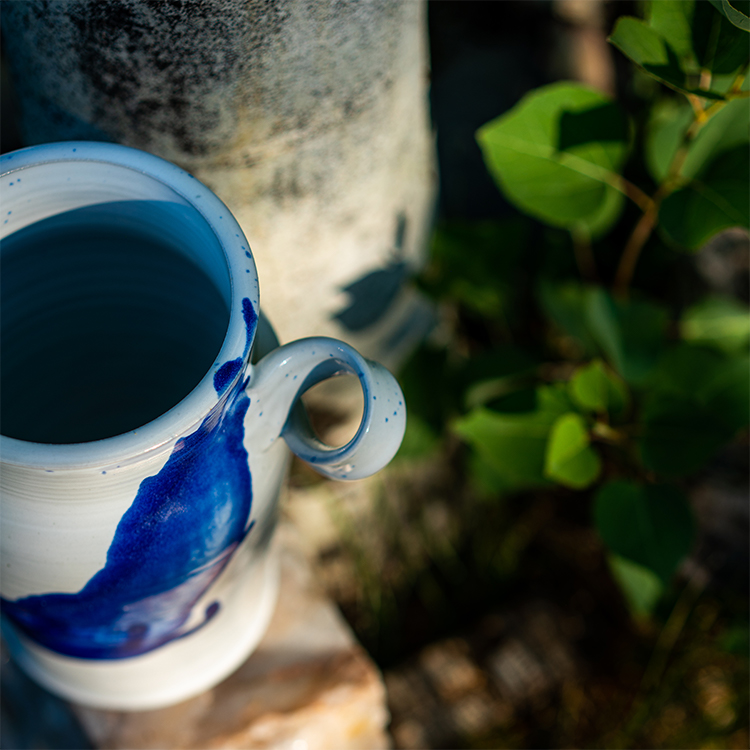 white and blue stoneware vase with twist handles by potter Converse Fields photographed outdoors by Justin Reiter in Steamboat Springs Colorado